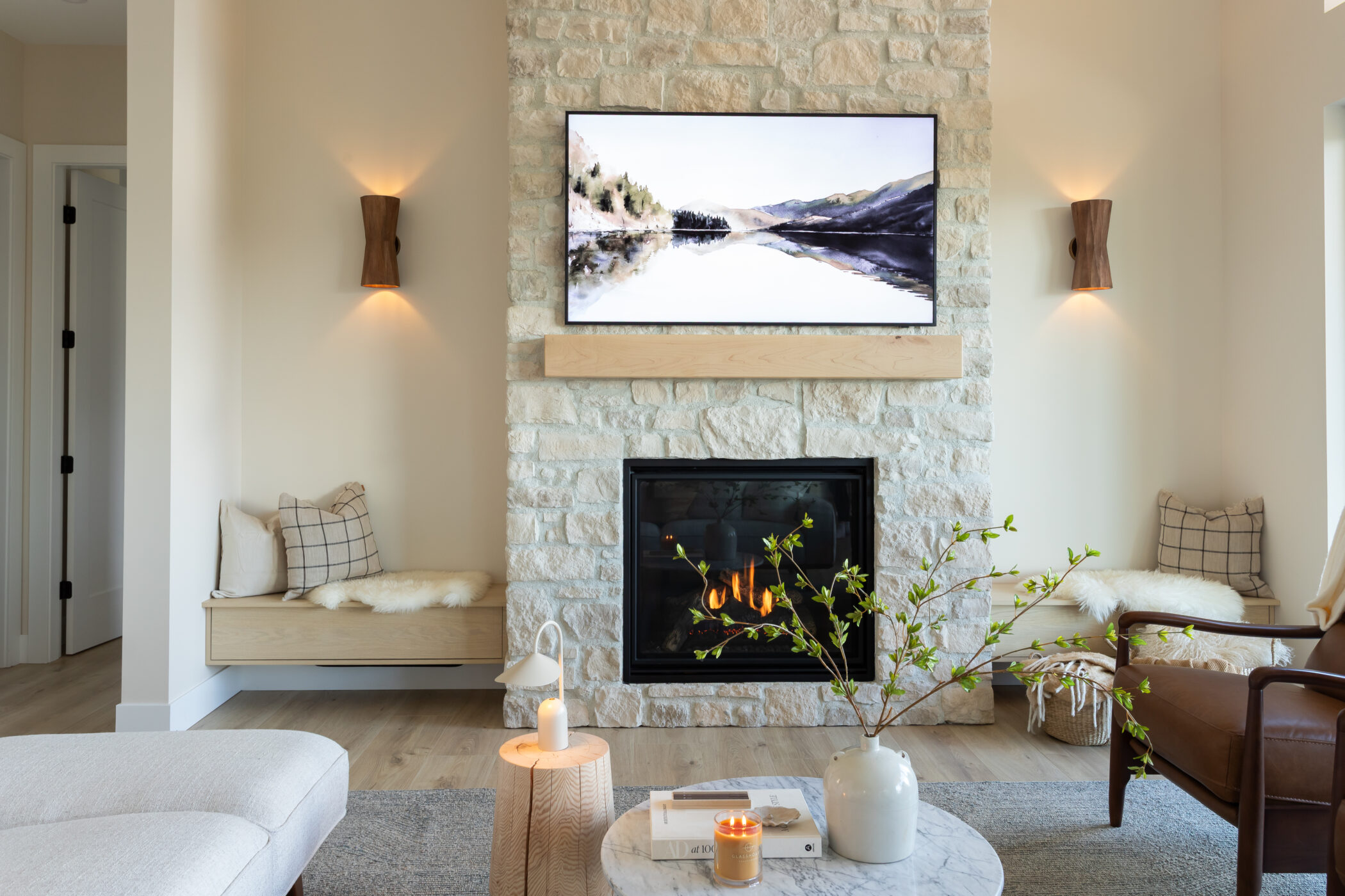 Luxury fireplace wall featuring natural stone and flat-screen TV in Kamloops home"