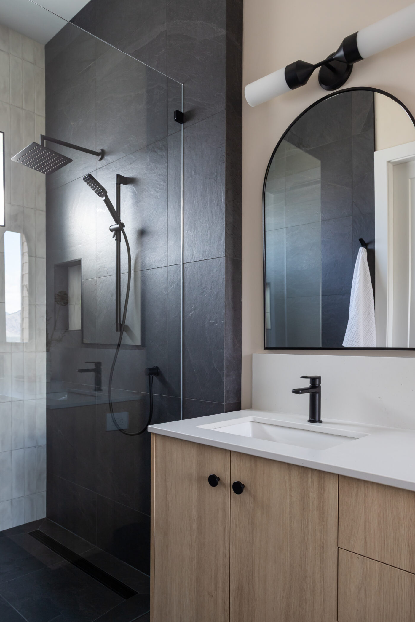 Modern bathroom with sleek black shower and minimalist design in custom Kamloops home