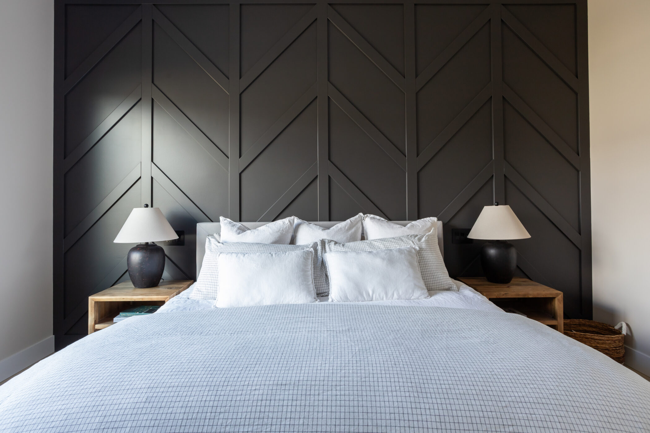 Elegant bedroom with painted wainscoting feature wall by custom home builder